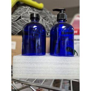 Two Blue Glass Bottles With Black Pumps For Outdoor Repellent Solutions